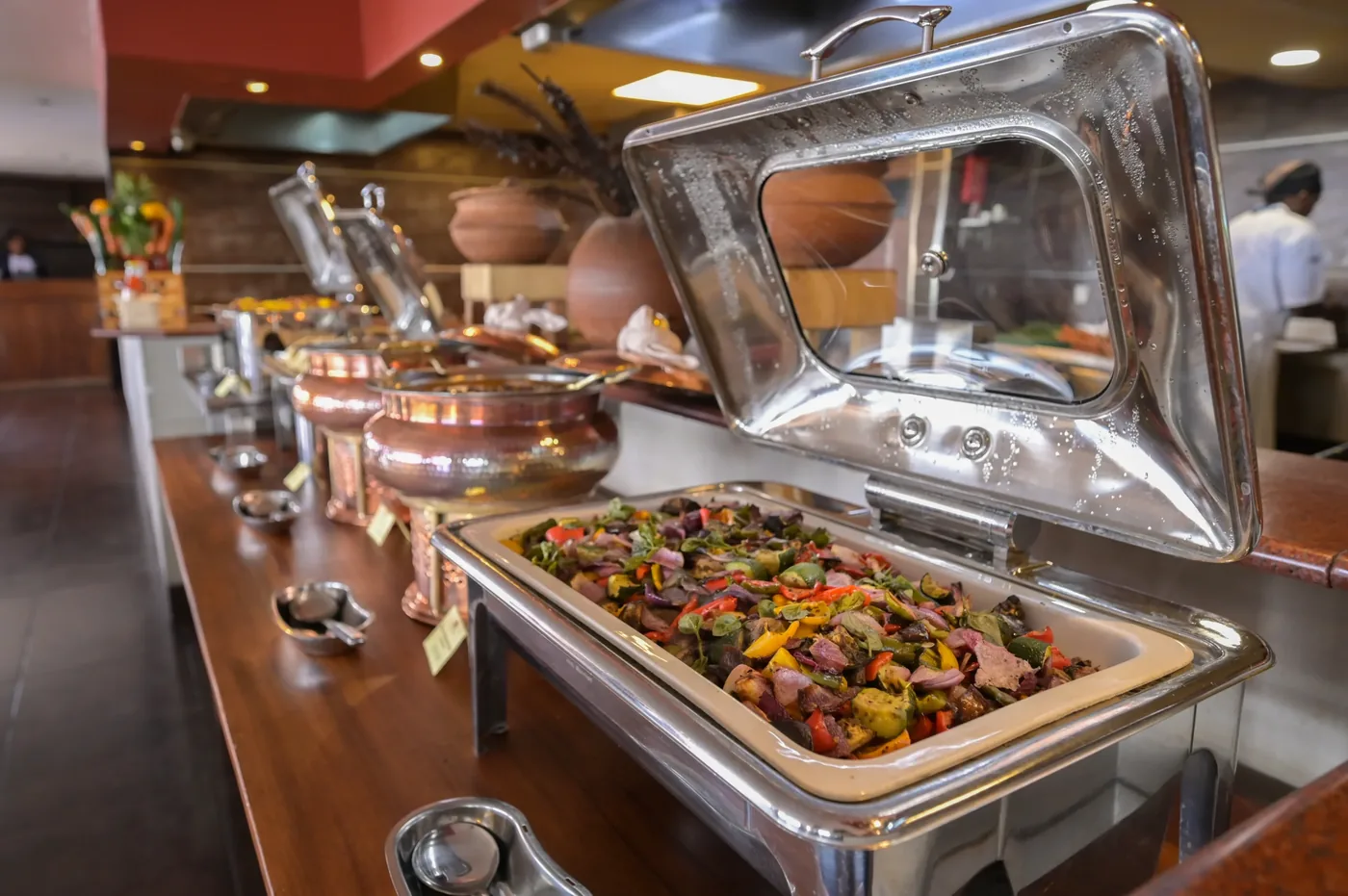 A buffet spread at Ole Sereni, chafing dishes of roasted vegetables